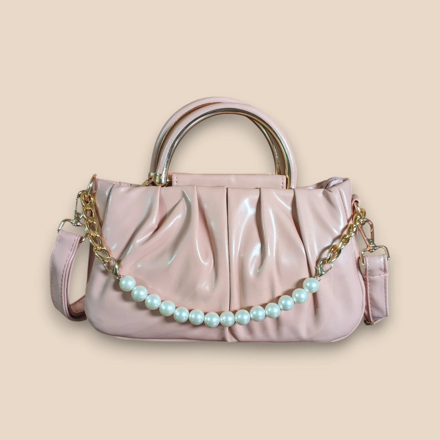 Pink handbag with a pearl chain on a beige background