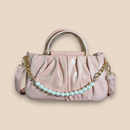 Pink handbag with a pearl chain on a beige background
