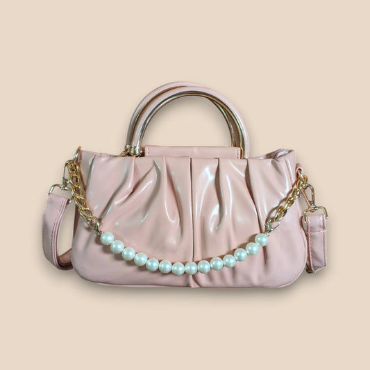 Pink handbag with a pearl chain on a beige background