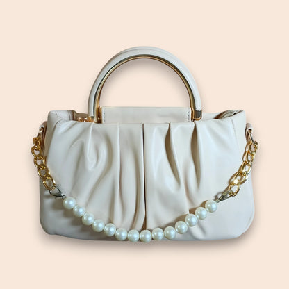 Off White handbag with gold chain and pearl details on a beige background